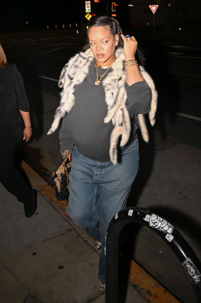 Rihanna walking in a sweatshirt jeans and fur shawl
